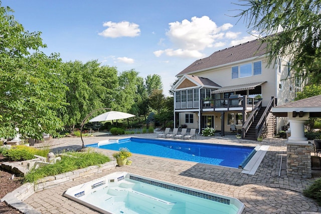 view of pool featuring a patio area, a jacuzzi, and a sunroom