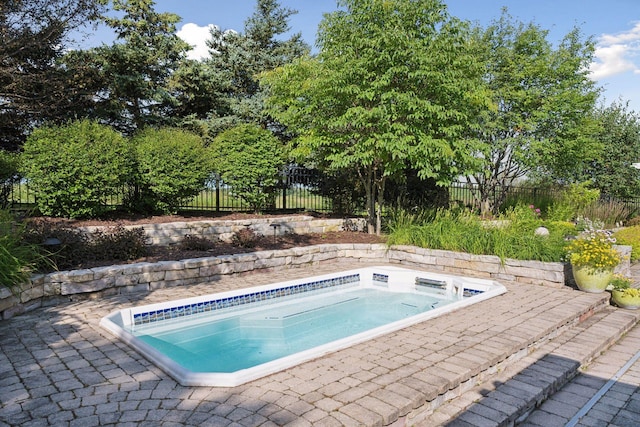 view of swimming pool with a patio area and an outdoor hot tub