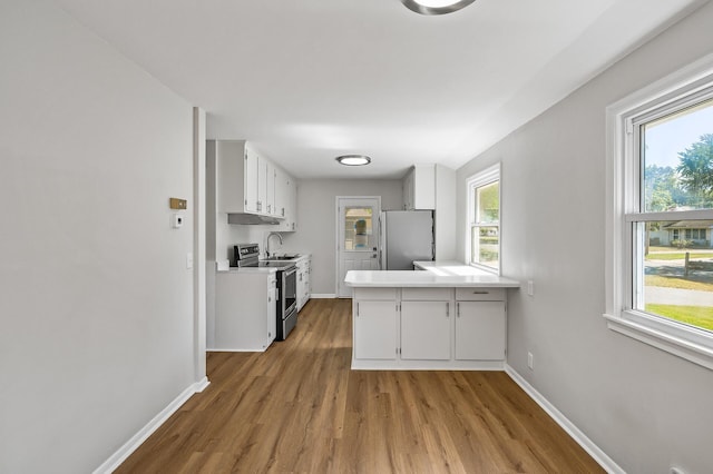 kitchen featuring white cabinets, light wood-type flooring, stainless steel appliances, and sink