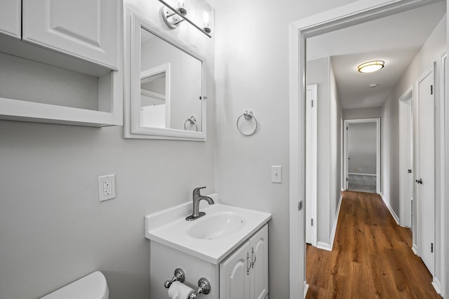 bathroom featuring hardwood / wood-style flooring, vanity, and toilet