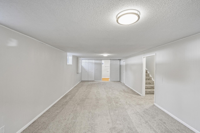 basement featuring a textured ceiling and light carpet