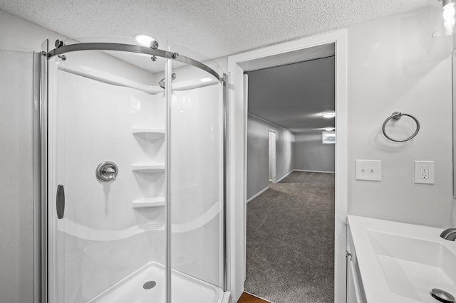 bathroom featuring vanity, a textured ceiling, and a shower with door