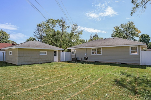 back of property with a yard and central air condition unit