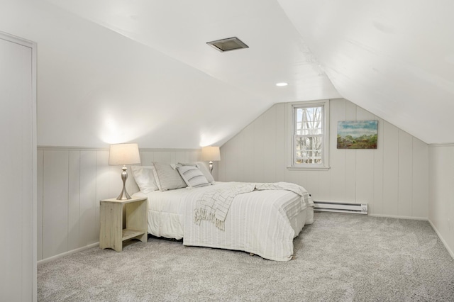 bedroom featuring vaulted ceiling, a baseboard heating unit, and light carpet