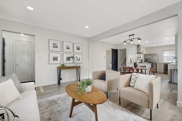 living room with beverage cooler and light wood-type flooring