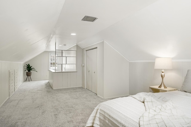 carpeted bedroom with vaulted ceiling and a closet