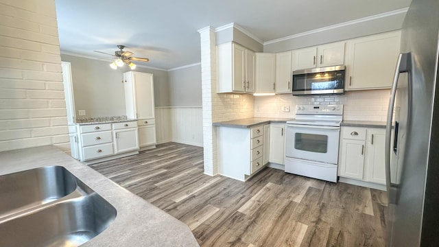 kitchen featuring stainless steel appliances, white cabinetry, and ornamental molding