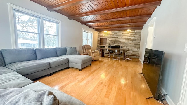 living room featuring baseboards, a stone fireplace, light wood-style floors, wooden ceiling, and beamed ceiling