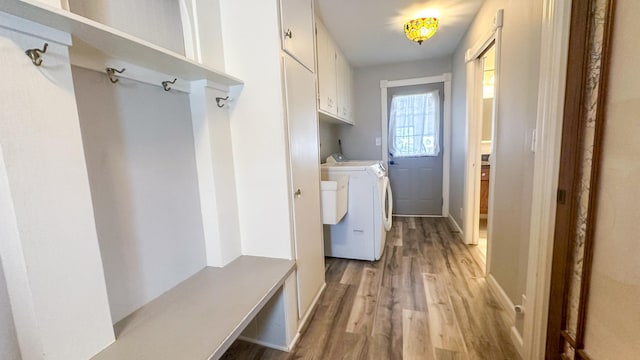 mudroom with separate washer and dryer and light wood finished floors