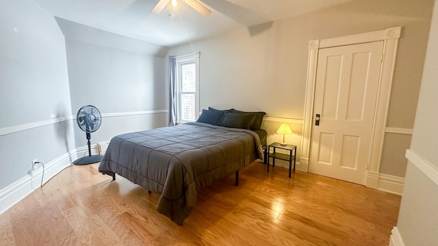 bedroom featuring ceiling fan, baseboards, and light wood-style floors