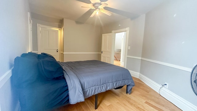 bedroom featuring baseboards, ceiling fan, and light wood finished floors