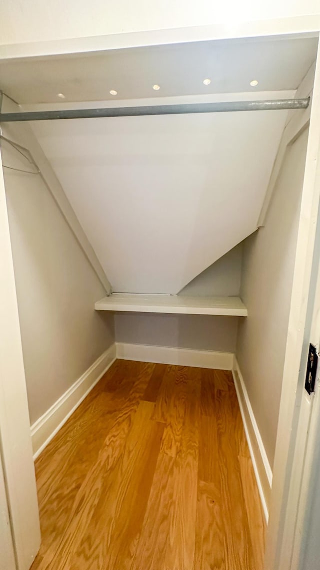 walk in closet with wood finished floors