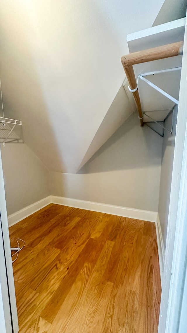 walk in closet featuring lofted ceiling and wood finished floors