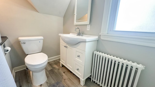 bathroom featuring radiator, toilet, vanity, and wood finished floors