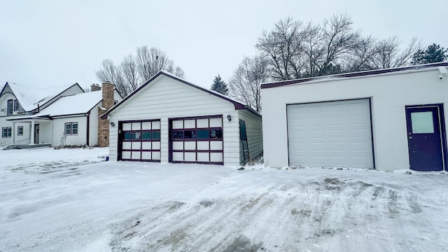 snow covered garage featuring a detached garage