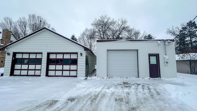 snow covered garage featuring a garage