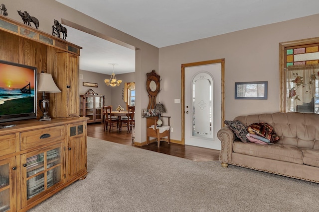 carpeted living room with an inviting chandelier