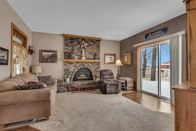 living room with a brick fireplace and carpet flooring