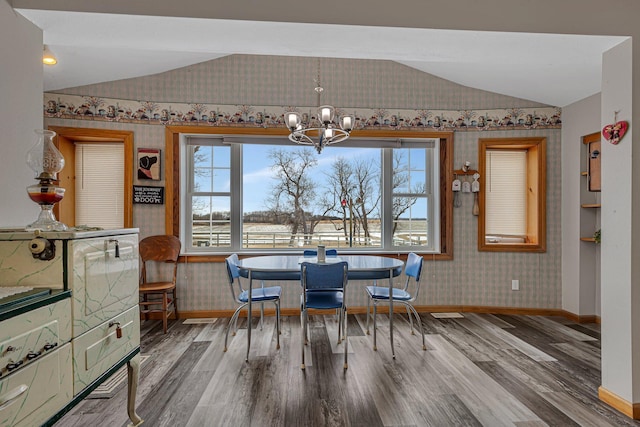 dining area with lofted ceiling, wood-type flooring, and a wealth of natural light