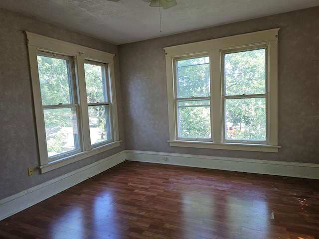 unfurnished room featuring a textured ceiling, ceiling fan, and dark hardwood / wood-style floors