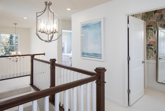 corridor with light colored carpet and a chandelier