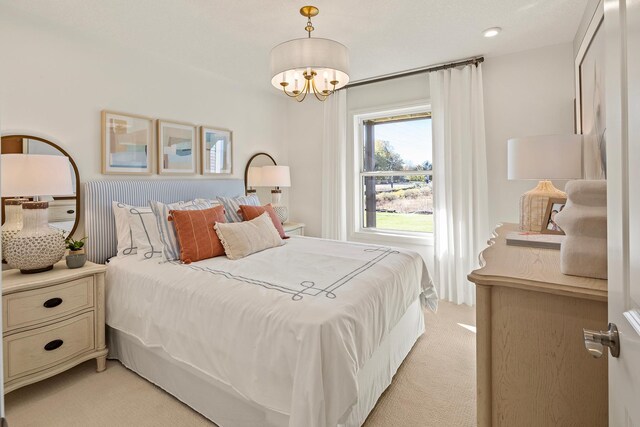 carpeted bedroom featuring an inviting chandelier