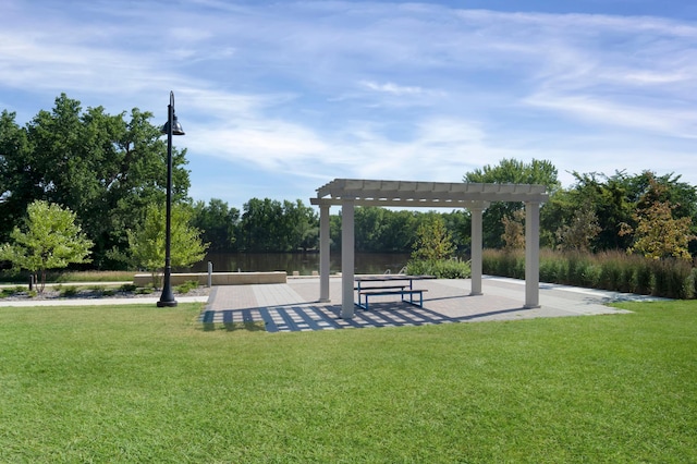 surrounding community with a pergola, a water view, and a yard