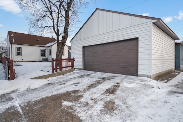 snow covered garage with central AC unit