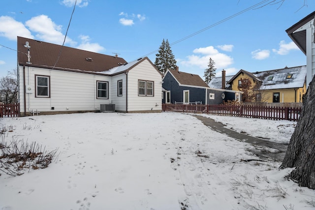 snow covered property with central air condition unit