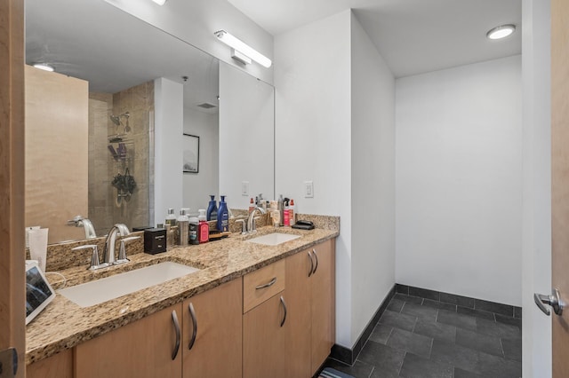 bathroom with tiled shower and vanity