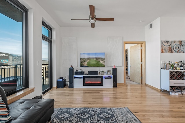 living room featuring ceiling fan and light hardwood / wood-style flooring