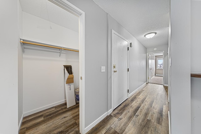 corridor featuring a textured ceiling and dark wood-type flooring