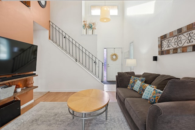 living room featuring a towering ceiling and hardwood / wood-style flooring