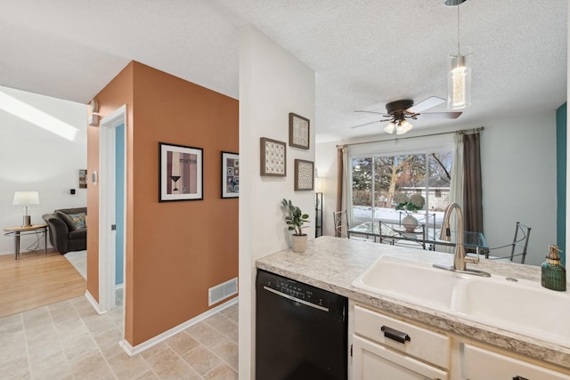 kitchen with pendant lighting, sink, a textured ceiling, and dishwasher