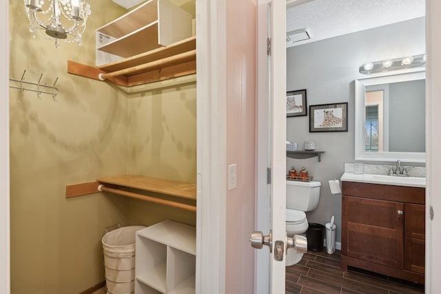 bathroom with vanity, toilet, and a textured ceiling