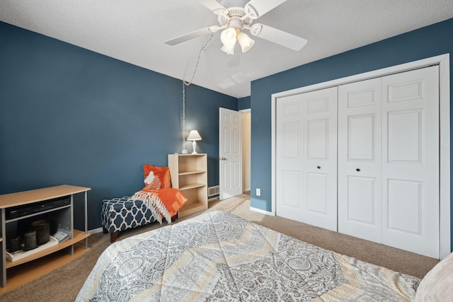 carpeted bedroom with a textured ceiling, a closet, and ceiling fan