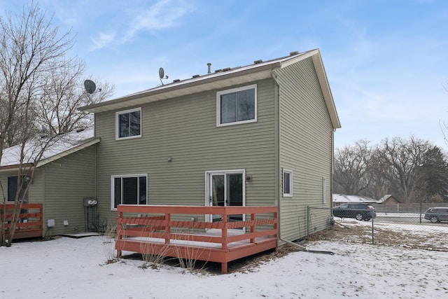 snow covered house featuring a wooden deck