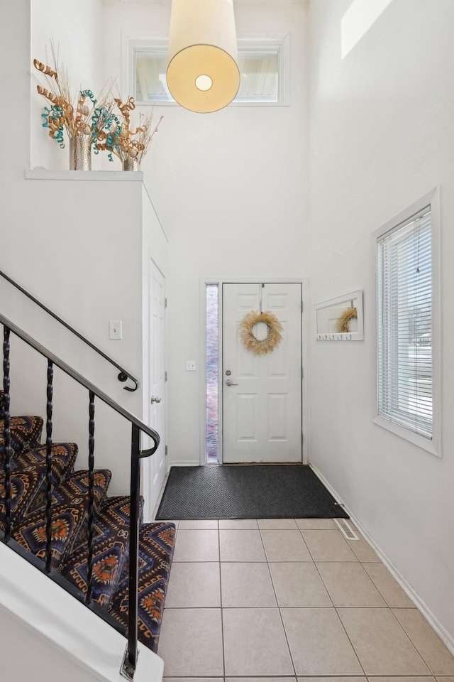 tiled foyer with a towering ceiling