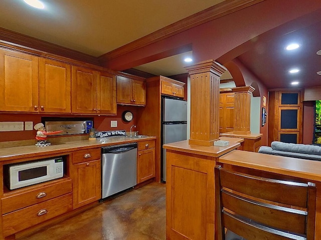 16694 206th Cir, Hutchinson, MN 55350 - kitchen featuring stainless steel appliances, ornate columns, a sink, concrete flooring, and brown cabinets