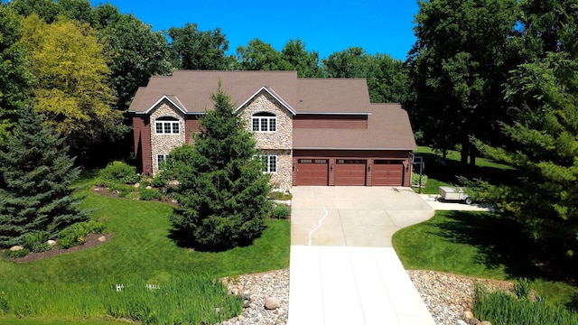 16694 206th Cir, Hutchinson, MN 55350 - view of front of property featuring driveway, stone siding, a front yard, and an attached garage