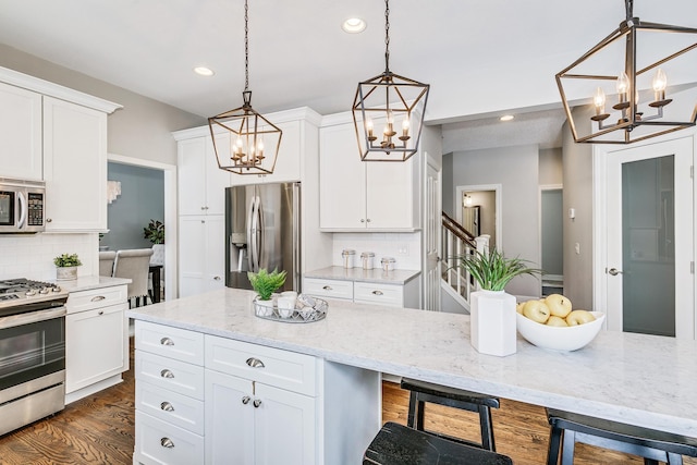 kitchen with white cabinetry, decorative backsplash, dark wood-style floors, and appliances with stainless steel finishes