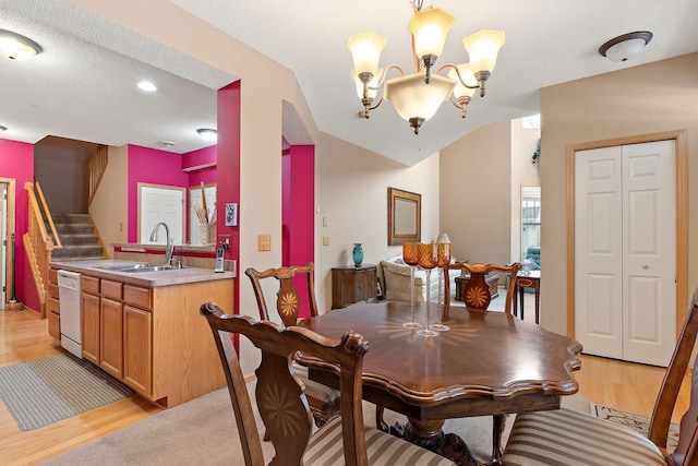 dining area with a notable chandelier, light wood finished floors, vaulted ceiling, a textured ceiling, and stairs