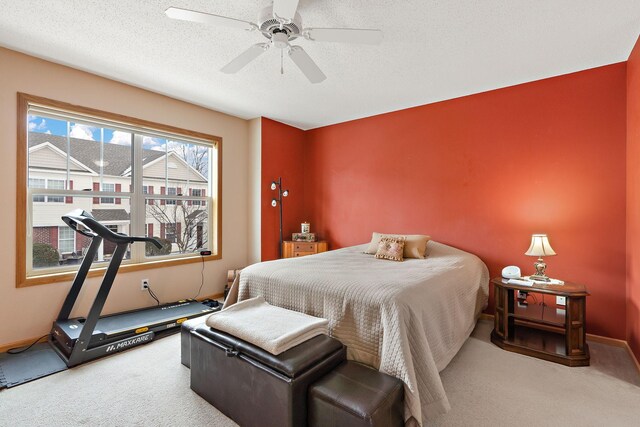 carpeted bedroom featuring ceiling fan, a textured ceiling, and baseboards