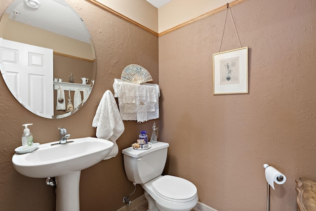 bathroom featuring a textured wall and toilet