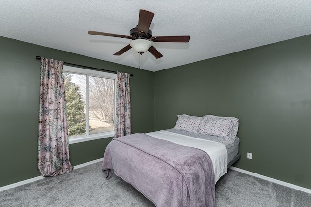 carpeted bedroom featuring a textured ceiling, a ceiling fan, and baseboards