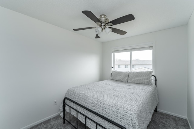 carpeted bedroom with ceiling fan and baseboards