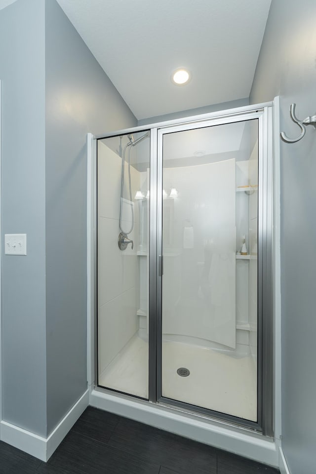 full bath with a shower stall, baseboards, wood finished floors, and recessed lighting