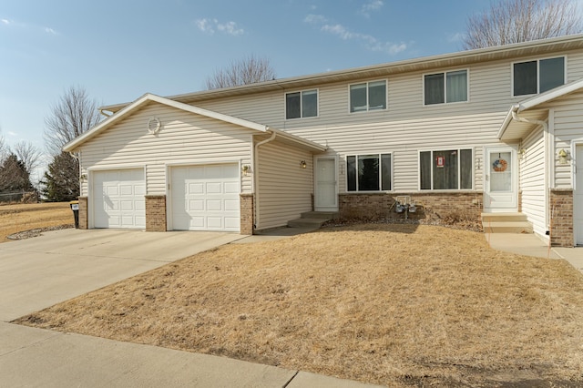 view of front of property with entry steps, concrete driveway, brick siding, and a garage