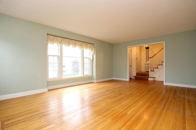 unfurnished living room with radiator and light hardwood / wood-style flooring