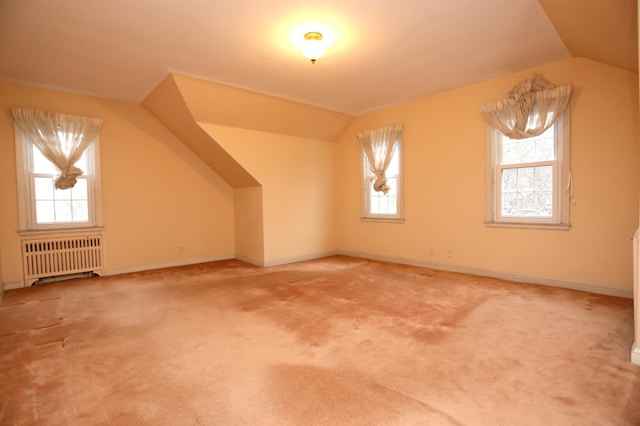 bonus room featuring lofted ceiling, radiator, and carpet